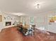 Spacious dining room with a cozy fireplace, large table, and natural light from multiple windows at 3232 Kale Ln, Matthews, NC 28105