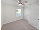 Bright bedroom with neutral carpet, ceiling fan and a sunlit window overlooking the yard at 3357 Ellingford Rd, Charlotte, NC 28214