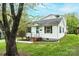 Charming white house with a landscaped front yard, blue front door, and mature tree at 390 15Th Ne Ave, Hickory, NC 28601