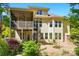 Back of house shows the deck, spiral staircase, many windows and mature trees at 404 Brookridge Dr, Mount Holly, NC 28120