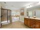 Bright bathroom features a glass shower, soaking tub, and vanity with a modern mirror and fixtures at 404 Brookridge Dr, Mount Holly, NC 28120