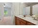 Bathroom with white countertops, wood cabinets, mirror, and view into bedroom with natural light at 404 Brookridge Dr, Mount Holly, NC 28120