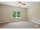 Simple, spacious bedroom with a ceiling fan and a large window showcasing the outside at 404 Brookridge Dr, Mount Holly, NC 28120
