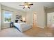 Cozy bedroom with a queen bed, blue accents, a ceiling fan, and a large window at 404 Brookridge Dr, Mount Holly, NC 28120
