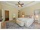 Neutral bedroom with tray ceilings, ensuite, large windows, and area rug at 404 Brookridge Dr, Mount Holly, NC 28120