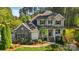 Two-story home with a stone facade, shutters, manicured landscaping, and an inviting front porch at 404 Brookridge Dr, Mount Holly, NC 28120