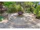 Inviting backyard fire pit area with decorative stone landscaping and a metal firepit at 404 Brookridge Dr, Mount Holly, NC 28120