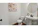 Clean half bathroom with pedestal sink, modern toilet, and wall decor at 404 Brookridge Dr, Mount Holly, NC 28120