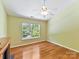 Bedroom features hardwood floors, large window, ceiling fan and neutral walls at 4143 Tullock Creek Dr, Charlotte, NC 28269
