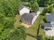 Aerial view of the home with a spacious backyard and wooden deck, surrounded by mature trees and lush greenery at 4219 Shasta Cir, Clover, SC 29710