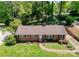 Aerial view of brick home with manicured lawn, colorful landscaping, and mature trees at 4925 Seacroft Rd, Charlotte, NC 28210
