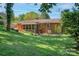 View of the backyard featuring an open yard, screened-in porch, and mature trees at 4925 Seacroft Rd, Charlotte, NC 28210