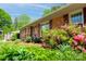 A beautiful brick house with colorful flowers, shrubs, and mature trees on a sunny day at 4925 Seacroft Rd, Charlotte, NC 28210
