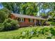 Beautiful brick home with lush landscaping, mature trees, and a well-maintained lawn at 4925 Seacroft Rd, Charlotte, NC 28210