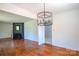 Open-concept living space with hardwood floors, a brick fireplace, and modern light fixture at 4925 Seacroft Rd, Charlotte, NC 28210