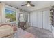 Bright bedroom features a ceiling fan, large closets, a window view, and patterned pillows at 7324 Pebblestone Dr # E, Charlotte, NC 28212