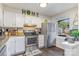Well-lit kitchen features granite countertops, stainless steel appliances, and white cabinets at 7324 Pebblestone Dr # E, Charlotte, NC 28212