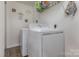 Well lit laundry room featuring a white washer and dryer, shelving for storage and modern vinyl floors at 7324 Pebblestone Dr # E, Charlotte, NC 28212