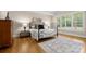 Bedroom with hardwood floors, white walls, a wrought iron bed frame, and a view of the backyard at 7600 Brookmont Ln, Waxhaw, NC 28173