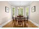 Dining room with wood table, chandelier, three windows with white shutters and hardwood floors at 7600 Brookmont Ln, Waxhaw, NC 28173