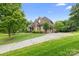 Spacious home with a long driveway, brick facade, mature trees, and well-maintained lawn at 7600 Brookmont Ln, Waxhaw, NC 28173