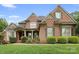 Charming brick home with manicured landscaping, symmetrical design, and inviting covered front porch at 7600 Brookmont Ln, Waxhaw, NC 28173