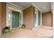Inviting brick front porch with a green door, shutters, and potted plants at 7600 Brookmont Ln, Waxhaw, NC 28173