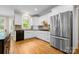 Bright kitchen featuring white cabinets, stainless steel refrigerator, and tiled backsplash at 7600 Brookmont Ln, Waxhaw, NC 28173