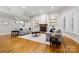 Bright living room featuring a brick fireplace, custom shelving, and hardwood floors at 7600 Brookmont Ln, Waxhaw, NC 28173