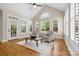 Sunroom with vaulted ceilings, a ceiling fan, two chairs, hardwood floors, and a sliding glass door at 7600 Brookmont Ln, Waxhaw, NC 28173