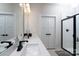 Bright bathroom featuring dual sinks, white cabinets, matte black hardware, and a tiled shower at 8419 Everwood Ave, Huntersville, NC 28078