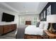 Stylish main bedroom featuring a tray ceiling, hardwood accent wall, neutral bedding and ample sunlight at 8419 Everwood Ave, Huntersville, NC 28078