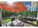 Outdoor kitchen with a grill and patio seating under an orange umbrella, perfect for entertaining at 10416 Glenmac Rd, Charlotte, NC 28215