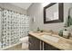 Well-lit bathroom featuring a modern vanity, a decorative shower curtain, and a neutral color scheme at 10416 Glenmac Rd, Charlotte, NC 28215