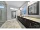Well-lit bathroom featuring double vanities with dark wood cabinetry and modern fixtures, creating a spa-like experience at 10416 Glenmac Rd, Charlotte, NC 28215
