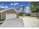 This large concrete drive leads to the brick garage with white doors at 10416 Glenmac Rd, Charlotte, NC 28215
