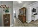 Bright hallway with wood-look flooring and display cabinets leading to the laundry room and a bathroom at 10416 Glenmac Rd, Charlotte, NC 28215