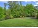 Manicured backyard with a black metal fence and lush trees provides privacy and a serene outdoor space at 10423 Drake Hill Dr, Huntersville, NC 28078