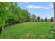 Fenced backyard with mature trees, a landscaped edge, and well-maintained lawn create a private oasis at 10423 Drake Hill Dr, Huntersville, NC 28078