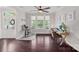 Bright home office featuring hardwood floors, a ceiling fan, and large windows offering abundant natural light at 10423 Drake Hill Dr, Huntersville, NC 28078