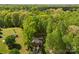 An aerial view displays a charming home nestled in a lush green forest, blending privacy with natural beauty at 109 Wren Ln, Mooresville, NC 28117