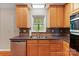 Well-lit kitchen features wooden cabinetry, granite countertops, tiled backsplash, and stainless steel dishwasher at 109 Wren Ln, Mooresville, NC 28117