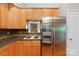 Kitchen with wooden cabinets, stainless steel refrigerator, granite countertops and view to the living room at 109 Wren Ln, Mooresville, NC 28117