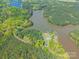 Picturesque aerial view of property with pool surrounded by lush trees and a glistening lake at 1308 Twin Oaks Dr, Chester, SC 29706