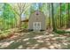 Barn featuring white crossbuck doors, a concrete driveway, and surrounded by lush trees at 1308 Twin Oaks Dr, Chester, SC 29706