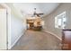 Open-concept living room flows into kitchen, featuring neutral tones, ample natural light, and carpeted flooring at 1308 Twin Oaks Dr, Chester, SC 29706