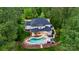 Aerial view of a luxury home with a pool and outdoor entertaining area surrounded by lush trees at 133 Crooked Branch Way, Troutman, NC 28166