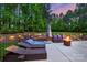 Secluded backyard boasts lounge chairs, sofa seating, and a warming fire pit for outdoor relaxation at 133 Crooked Branch Way, Troutman, NC 28166