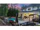Backyard featuring a pool, a covered patio with seating, and lush landscaping at twilight at 133 Crooked Branch Way, Troutman, NC 28166