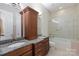 This bathroom features granite countertops, double sinks, and a glass-enclosed shower and tub at 133 Crooked Branch Way, Troutman, NC 28166